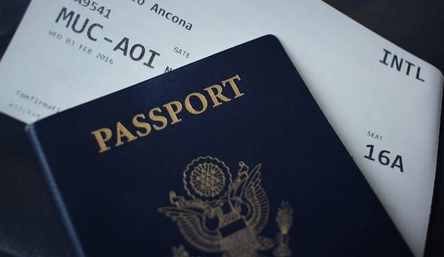 Un pasaporte de tapa azul oscura apoyado sobre una tarjeta de embarque de avión
